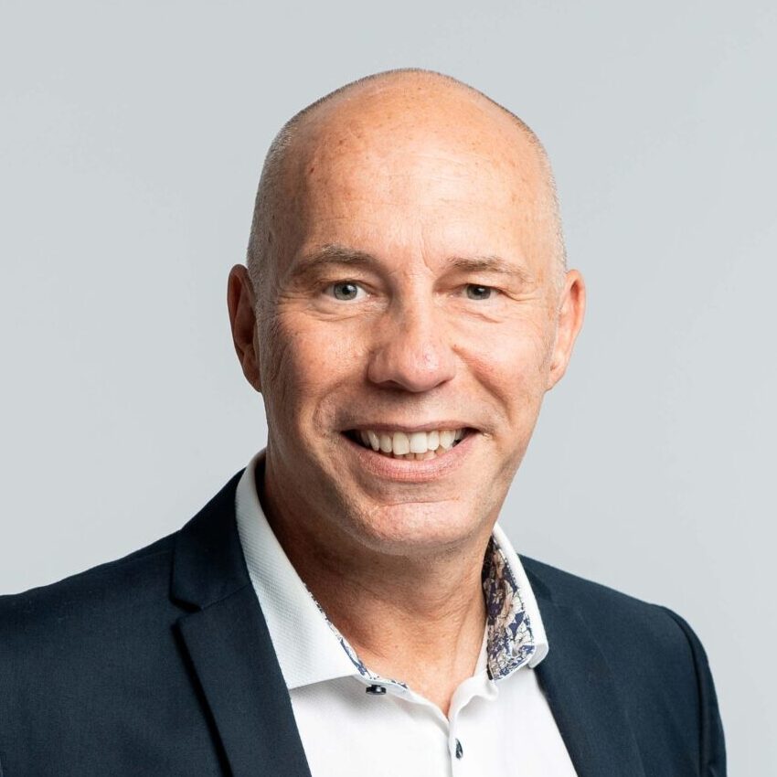 Portraitfoto eines Mannes mit Glatze, dunklem Sakko und weißem Hemd